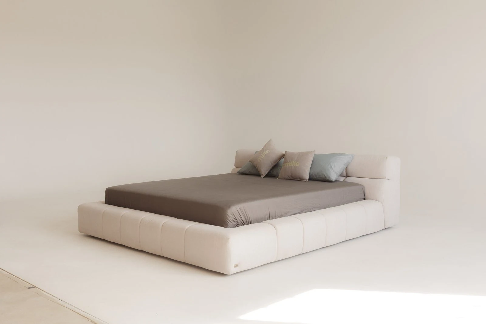 Cream velvet Nao bed photographed from the side in a bright minimal studio