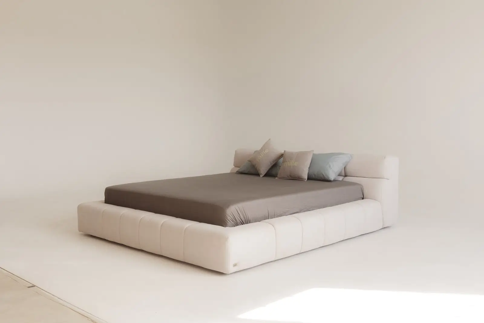 Cream velvet Nao bed photographed from the side in a bright minimal studio