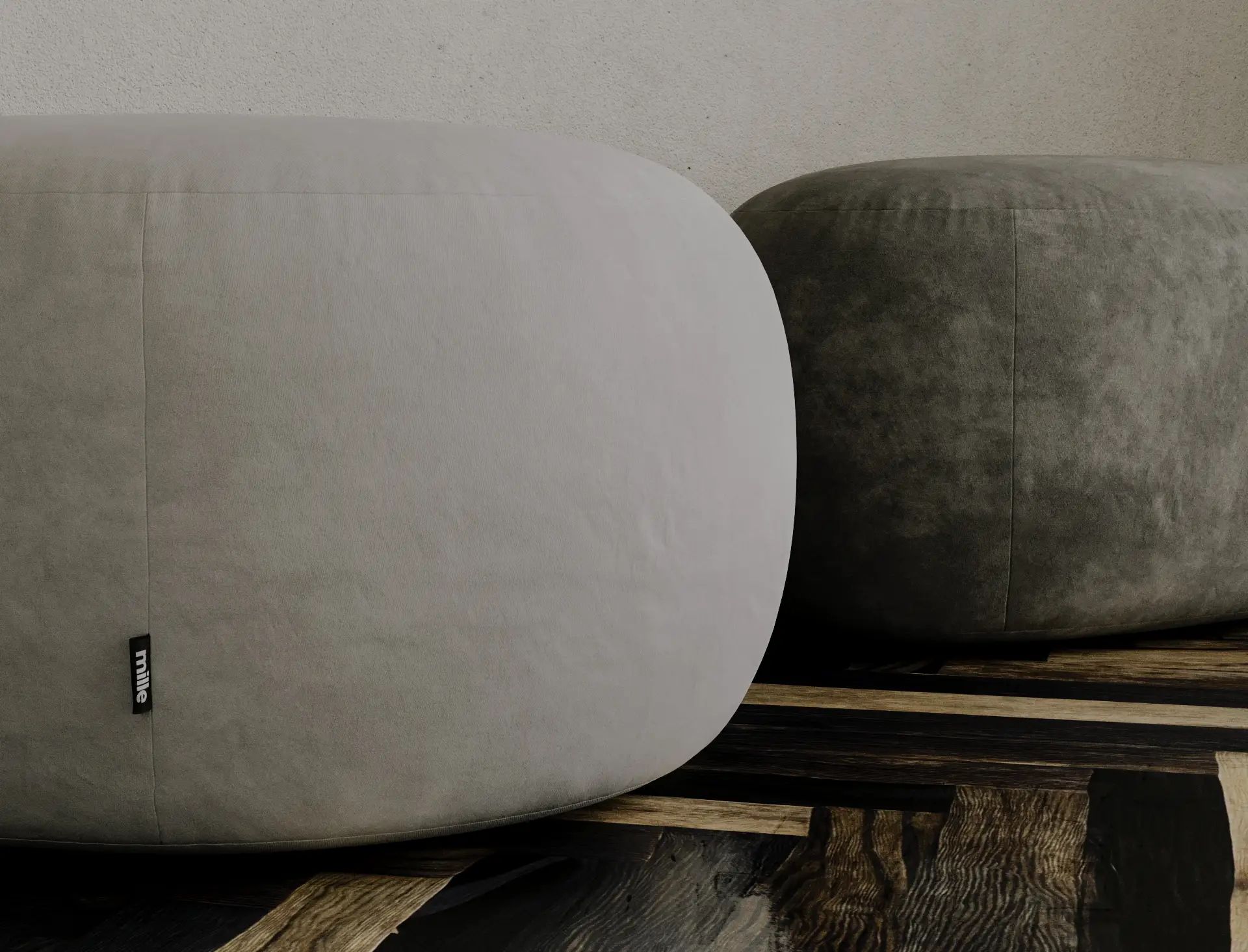 Two grey velvet Chios poufs together on a dark parquet floor