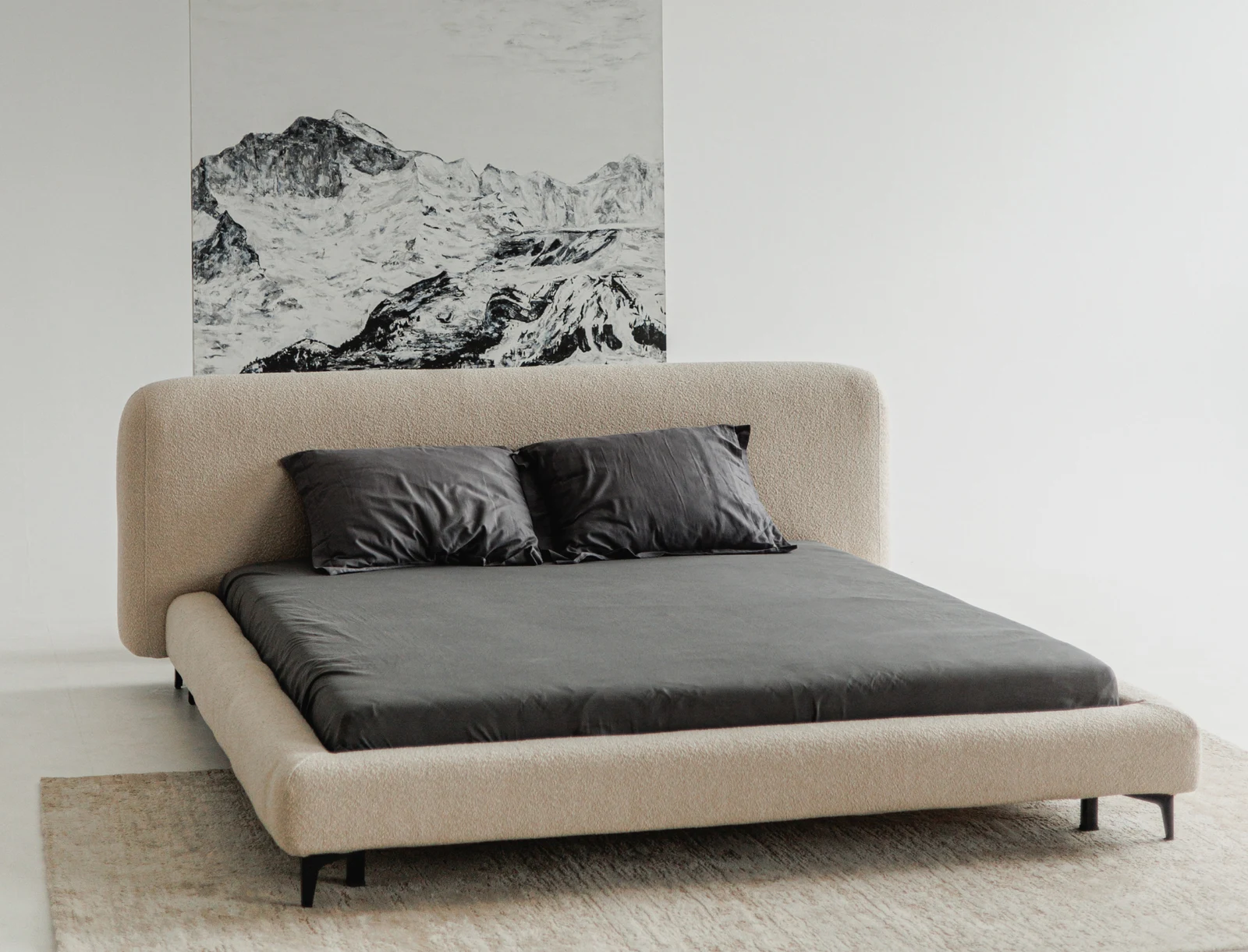 Three-quarter view of the sand Fresco bed in a clean studio with the mountain artwork behind