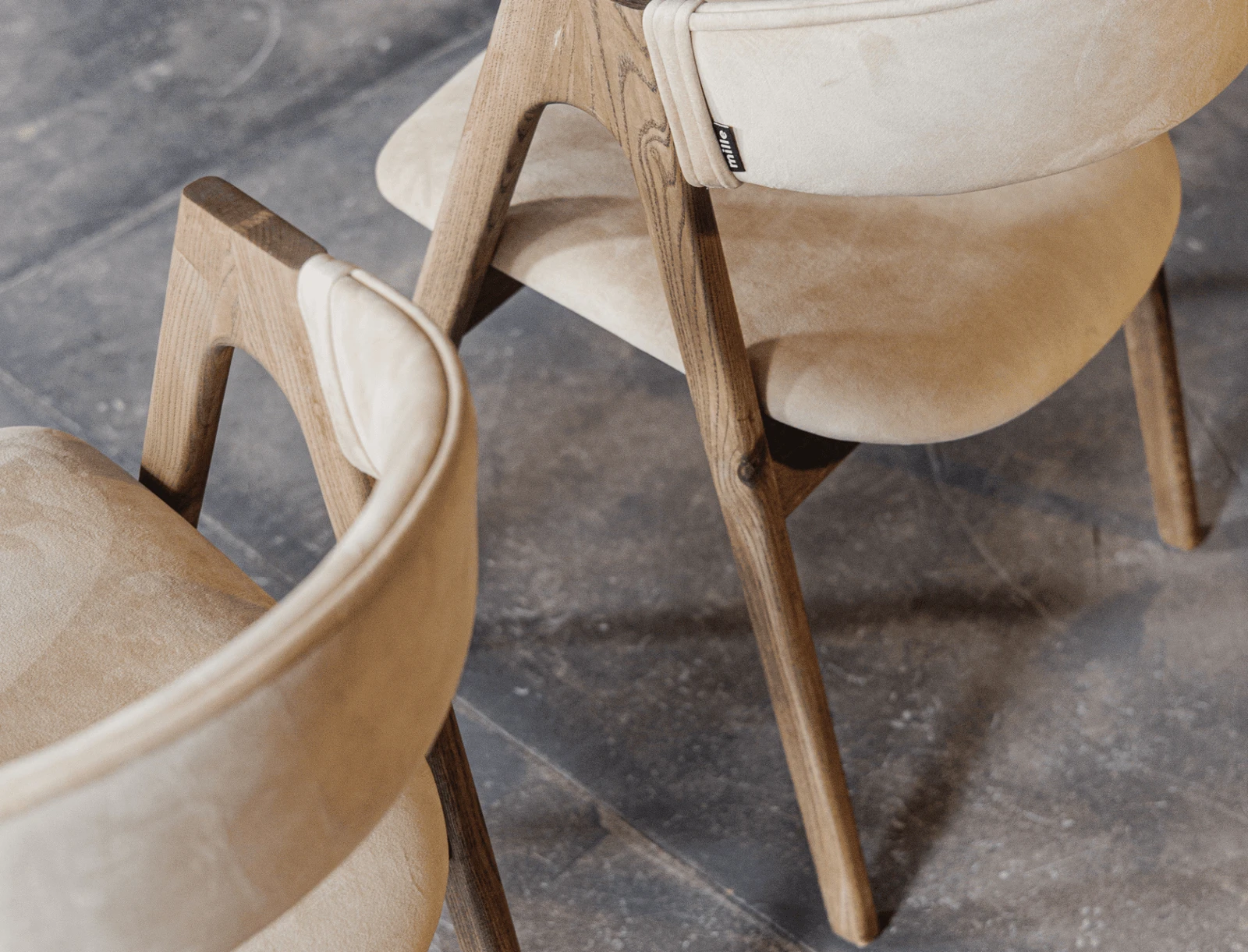 Side angle of the light beige Lain chair in the library showing the sawhorse frame