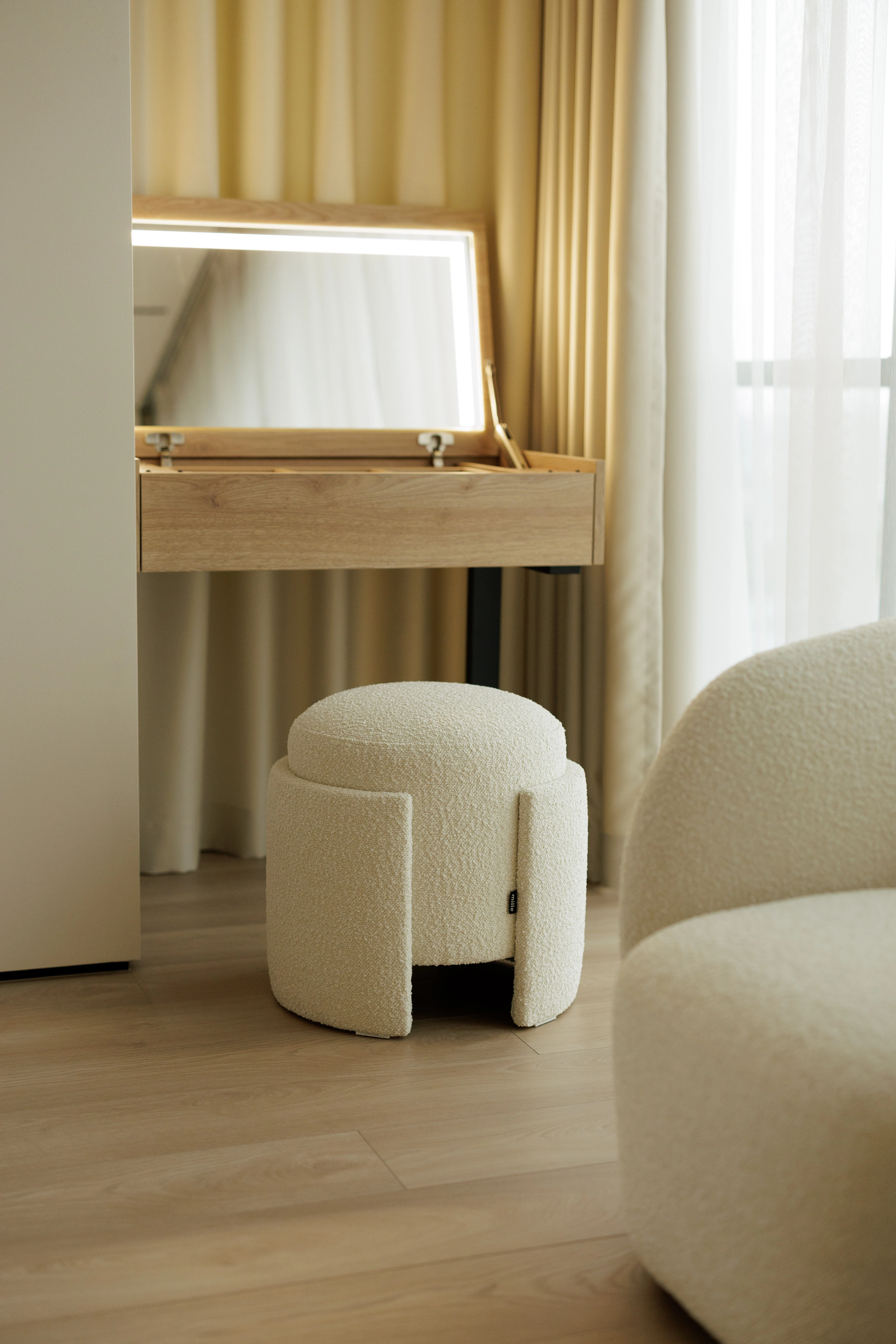Eden pouf at a vanity with an illuminated mirror