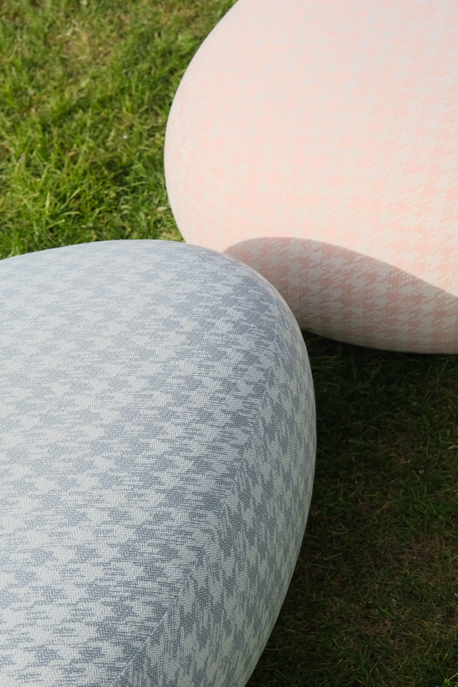 Close detail of the houndstooth weave on two Chios poufs in grass