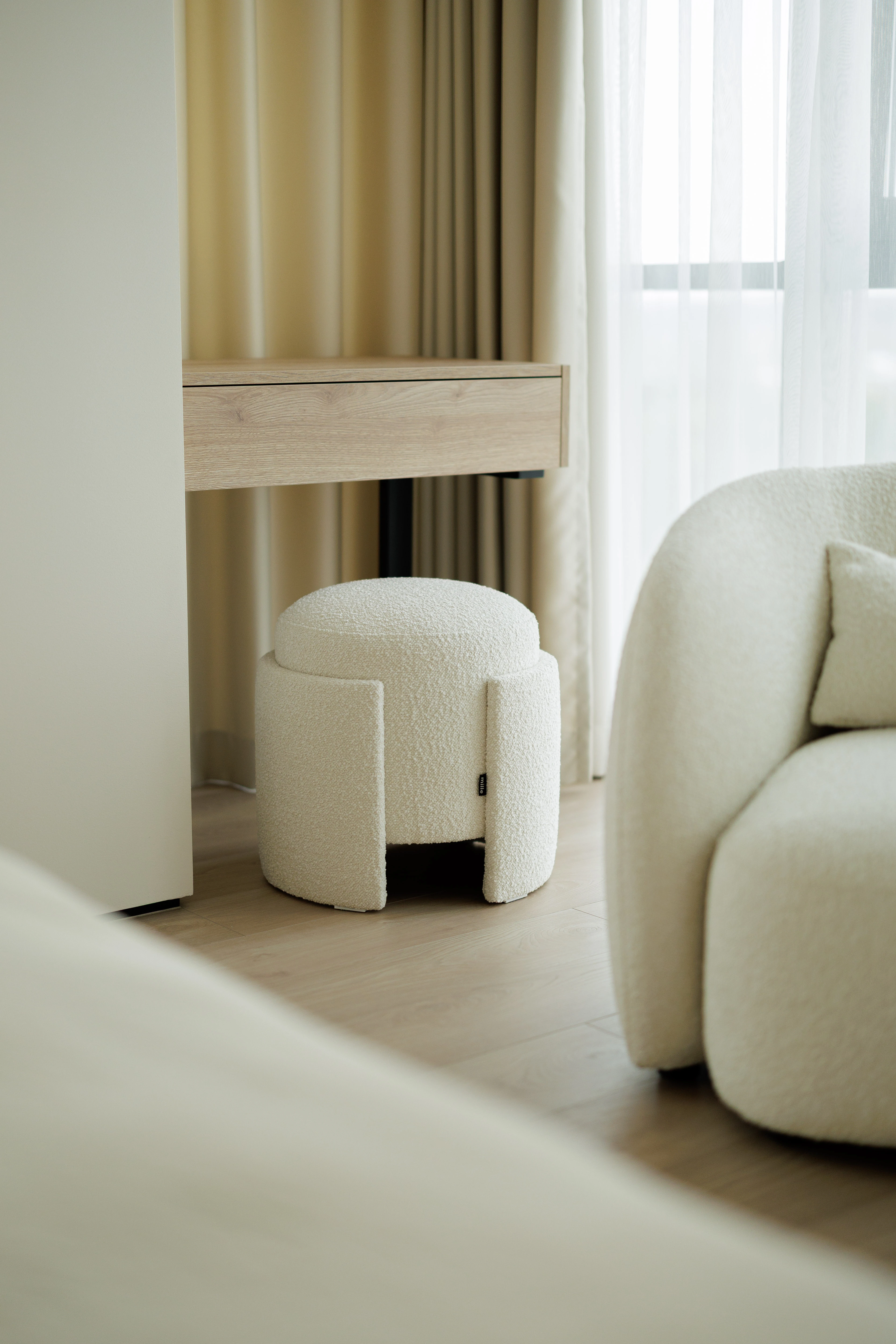 Eden pouf at the vanity beside a bouclé armchair