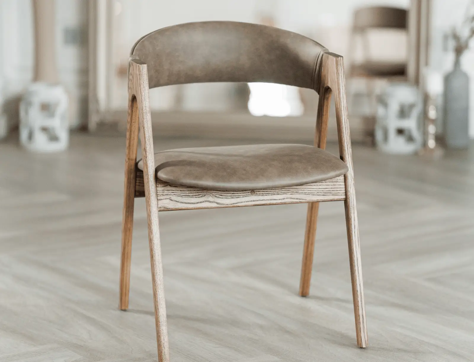 Three-quarter view of the coffee leather Lain chair near the mirror
