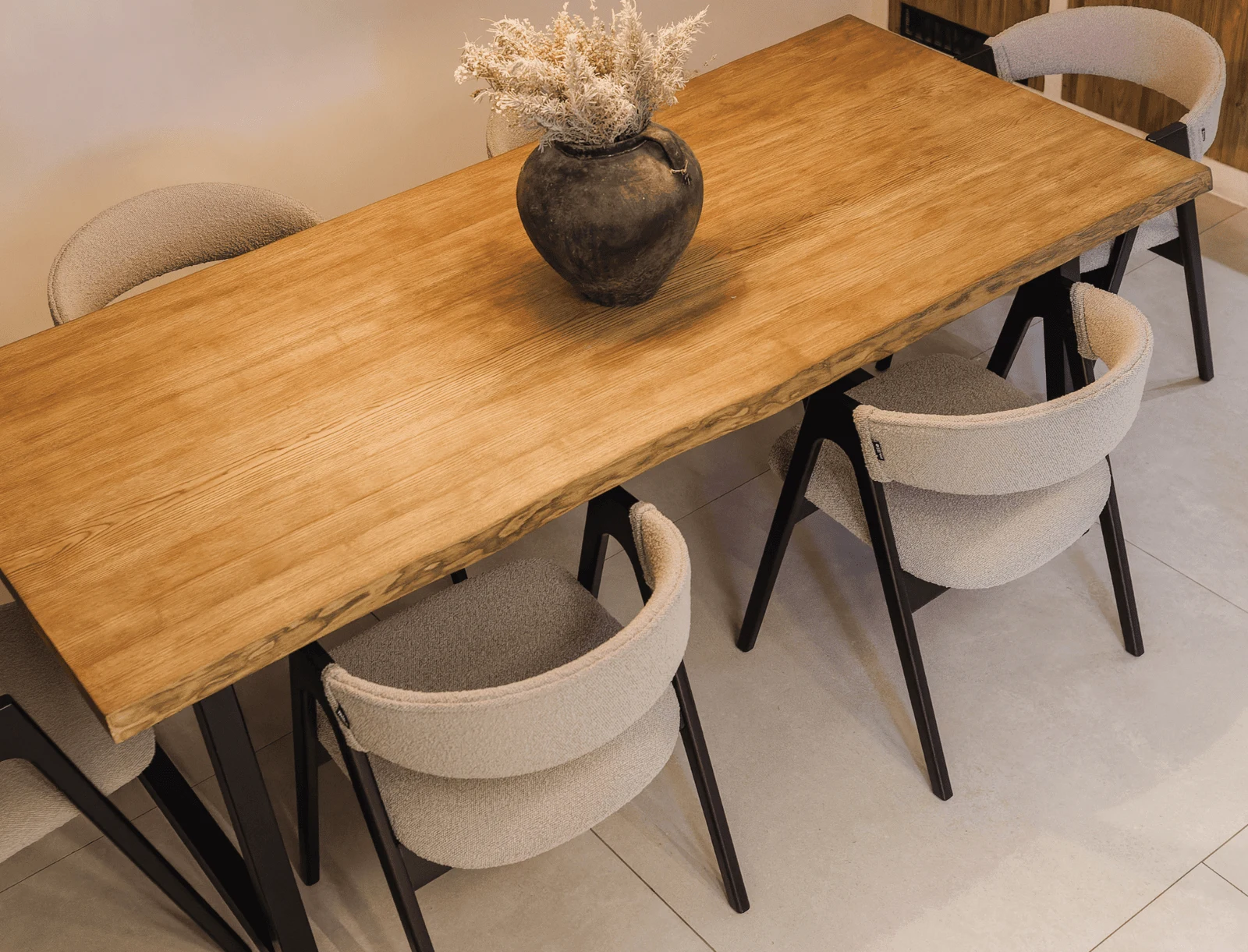 Frame detail of the cream boucle Lain chair showing the black-stained ash joinery
