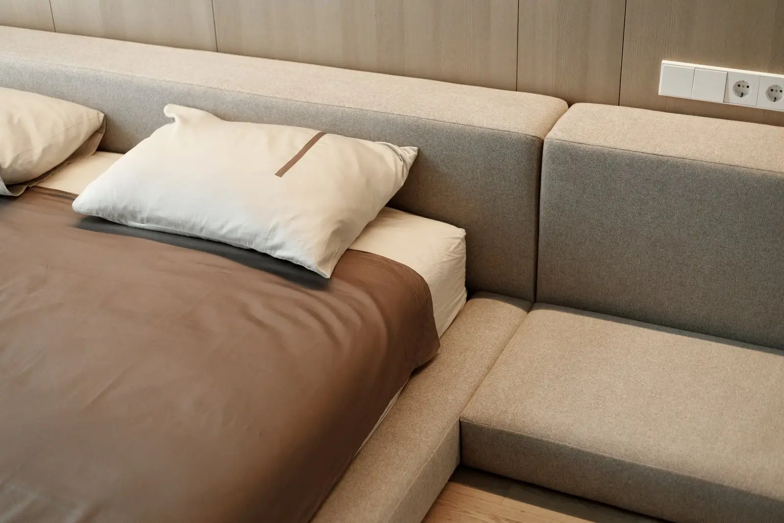 Pillows arranged in front of the Connect's back cushion modules with wood-paneled wall behind
