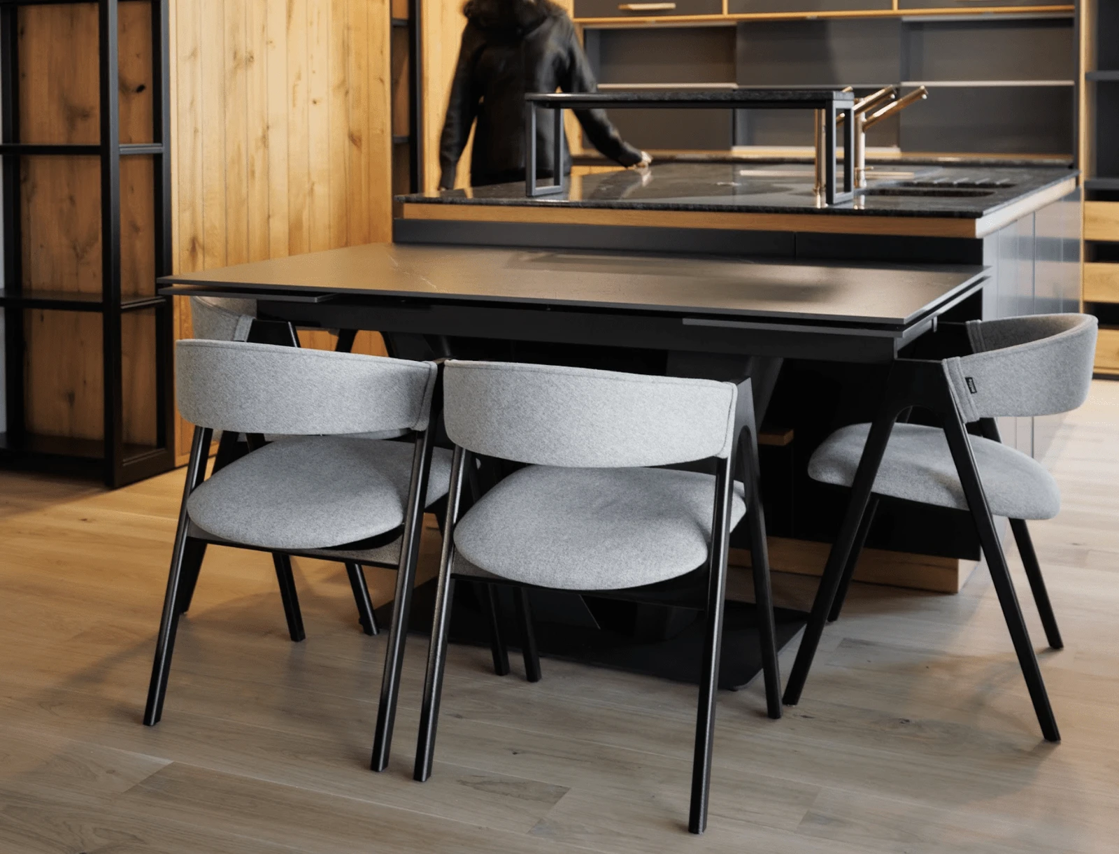Detail of the grey Lain chair pulled up to the dark kitchen island