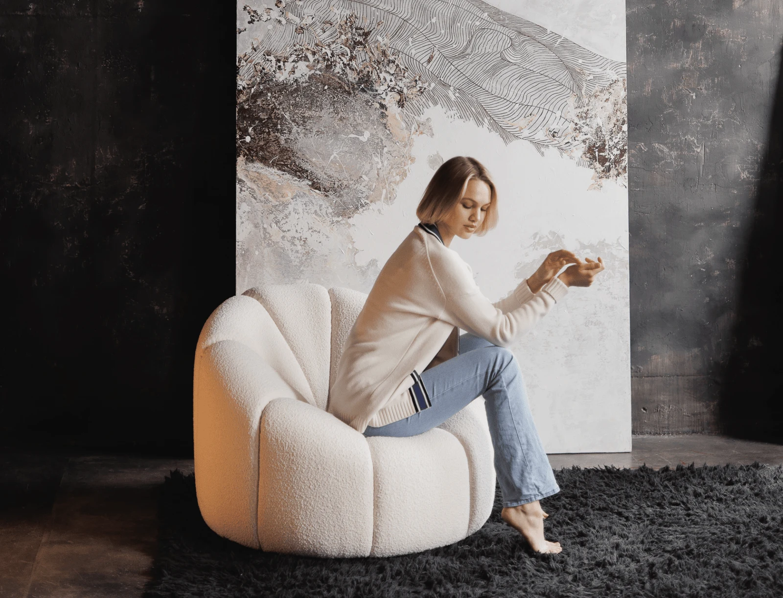 Side view of the Flora chair in the moody interior with dark wall behind