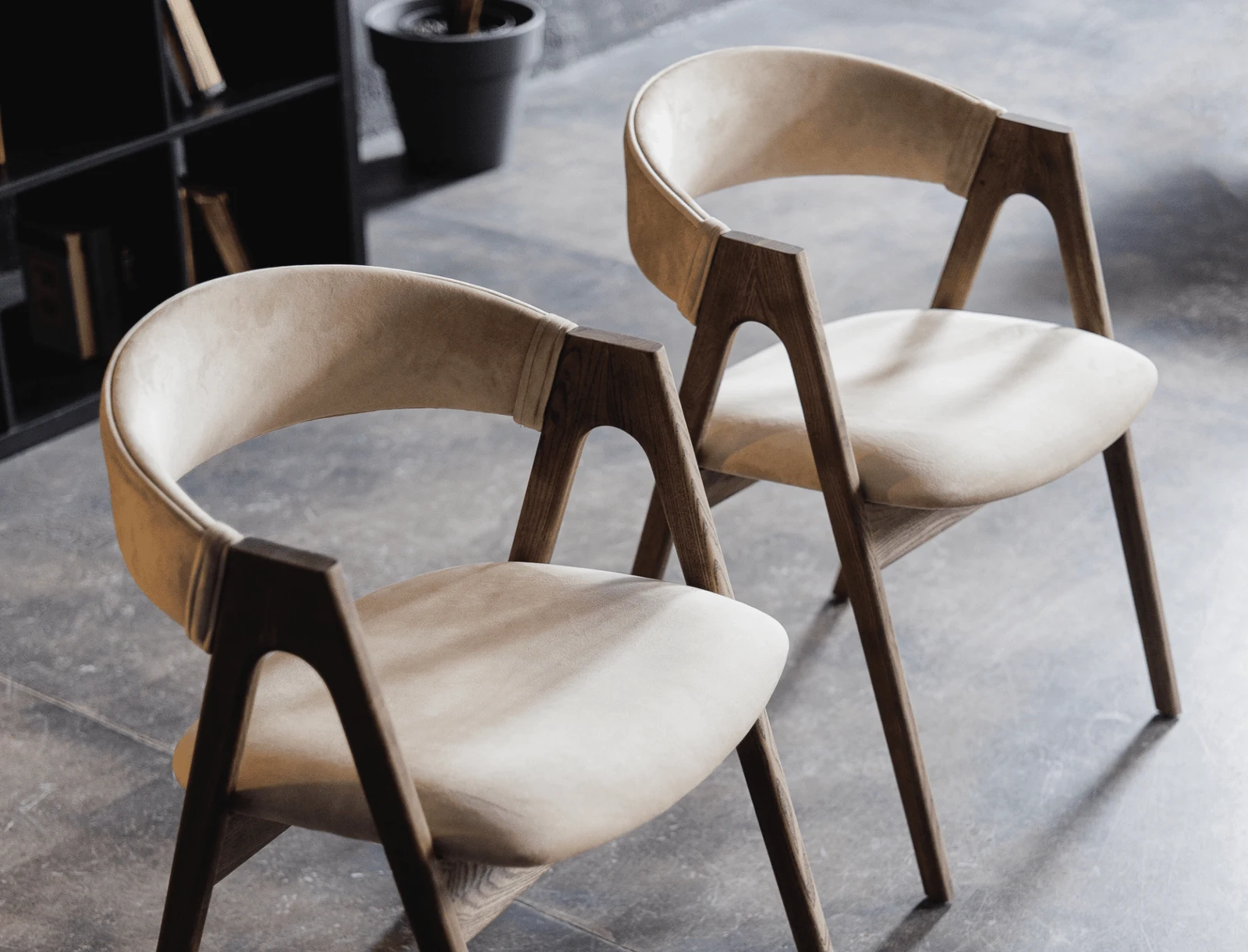 Detail of the light beige Lain chair's natural-ash frame in the library