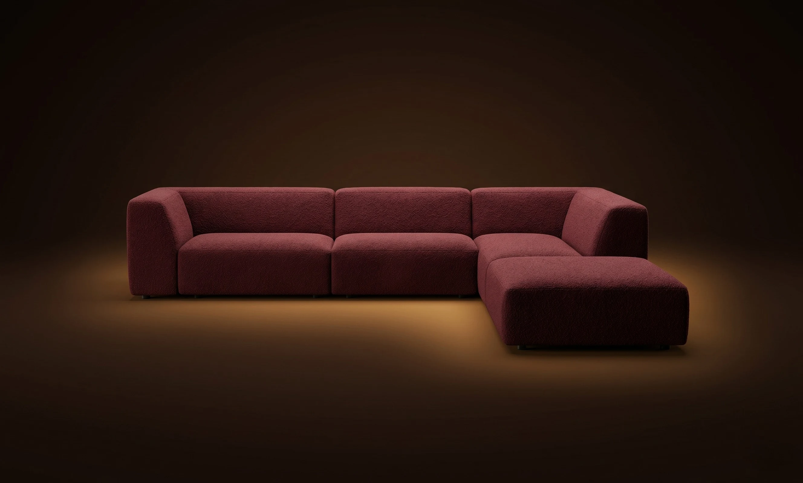 A burgundy Mille L with a detached ottoman, in a dark studio