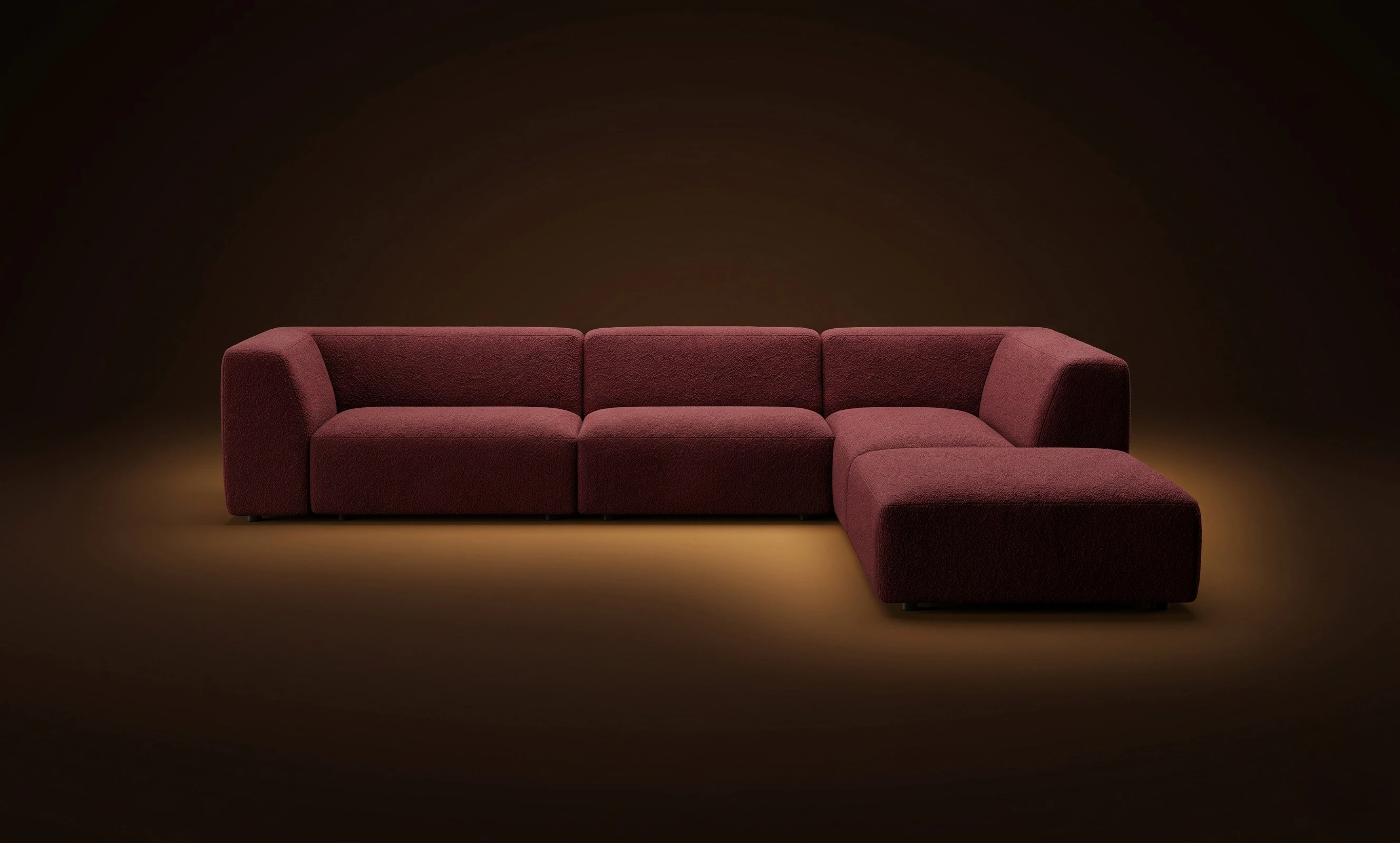 A burgundy Mille L with a detached ottoman, in a dark studio