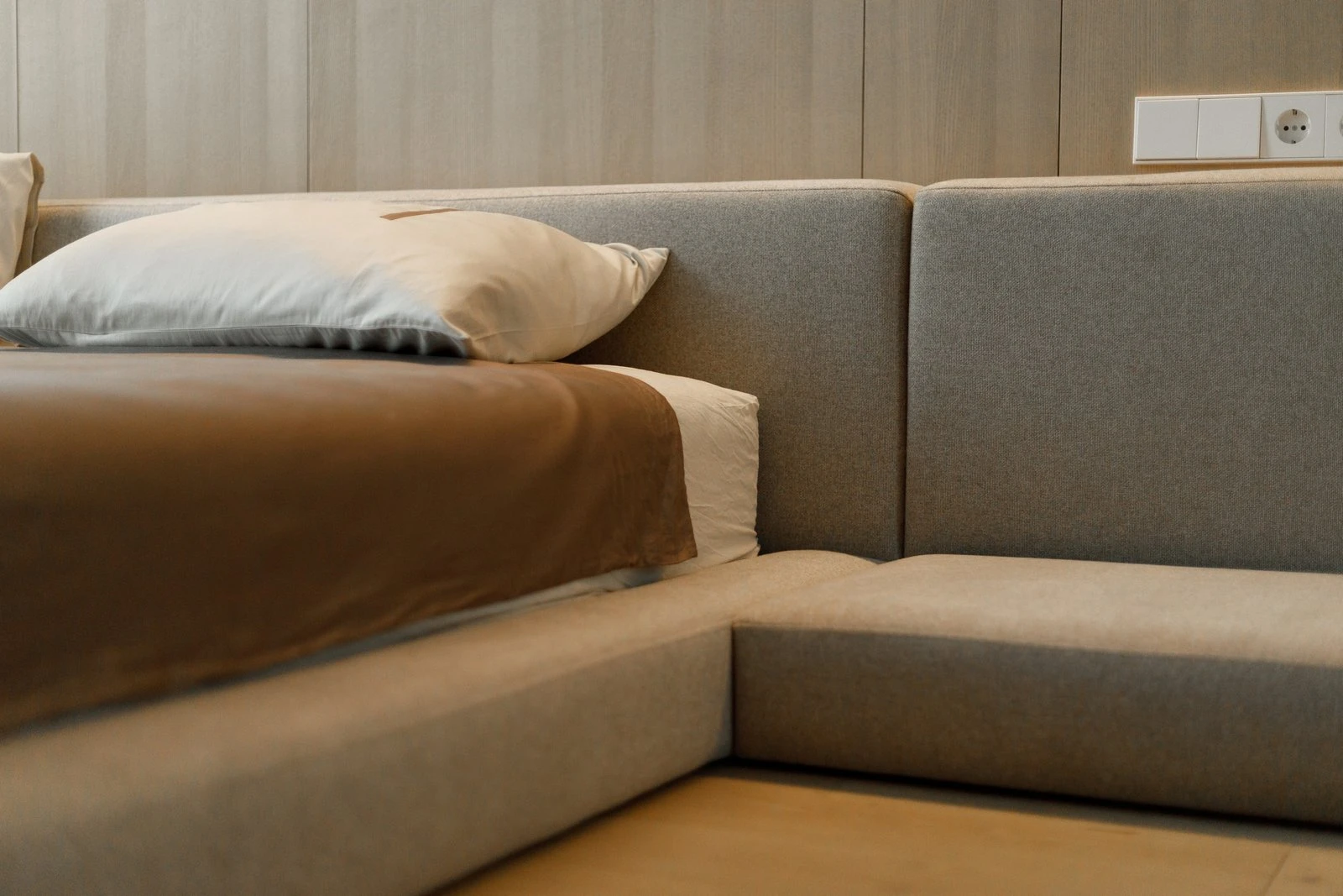 Three-quarter detail of the Connect side bench extension with wood-paneled wall and electrical outlets behind