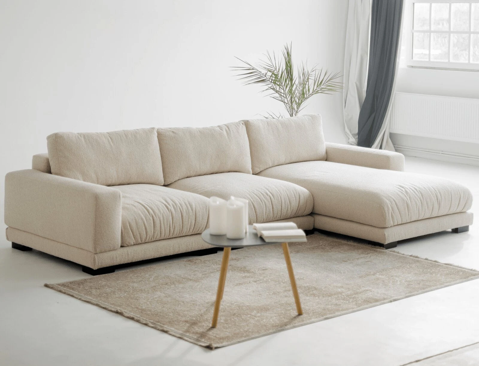Cream Palermo sectional with chaise in a softly lit living room with pillar candles on a marble side table