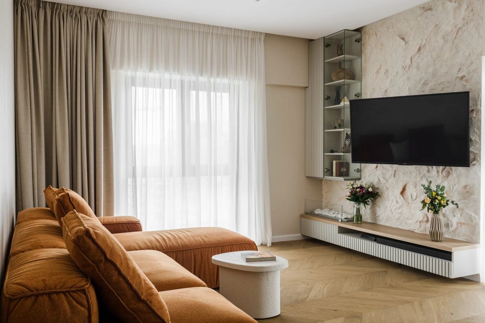 Cognac Milano sectional in an apartment with herringbone floors and sheer curtains
