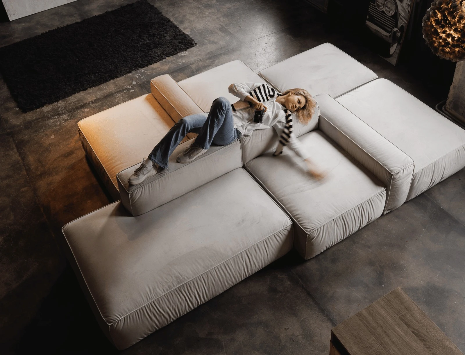 Overhead view of a cream Milano L-shape with a person resting across two modules