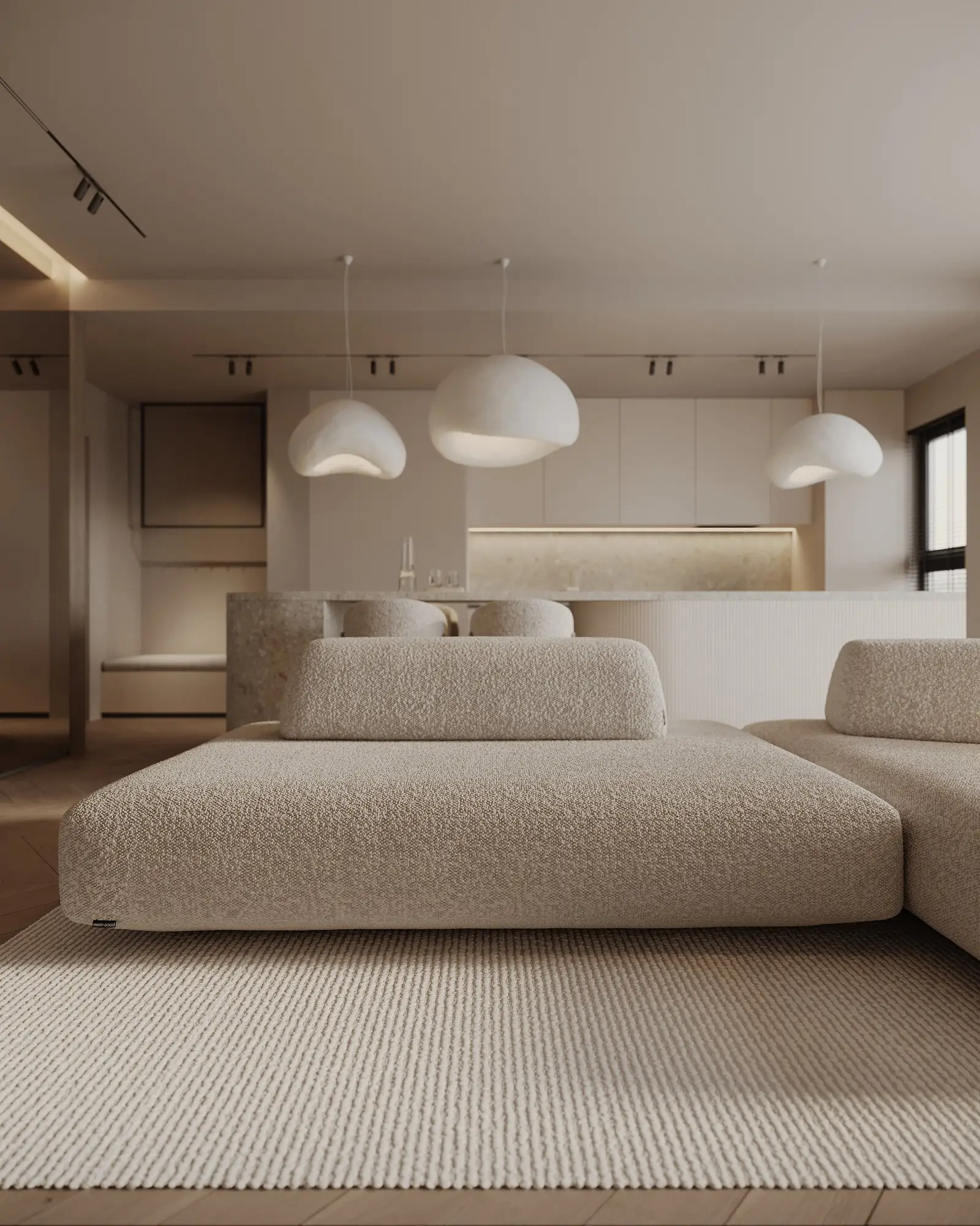 Close view of the cream Deseda beneath sculptural cream pendants in a warm apartment