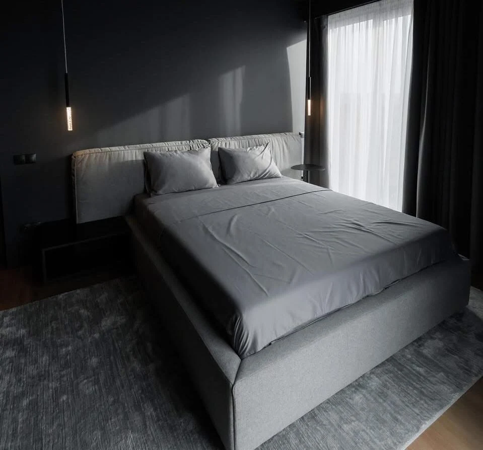 Mid-grey Soho 805 Palermo bed in a dark-walled bedroom with hanging tube pendants and Mille-branded pillows