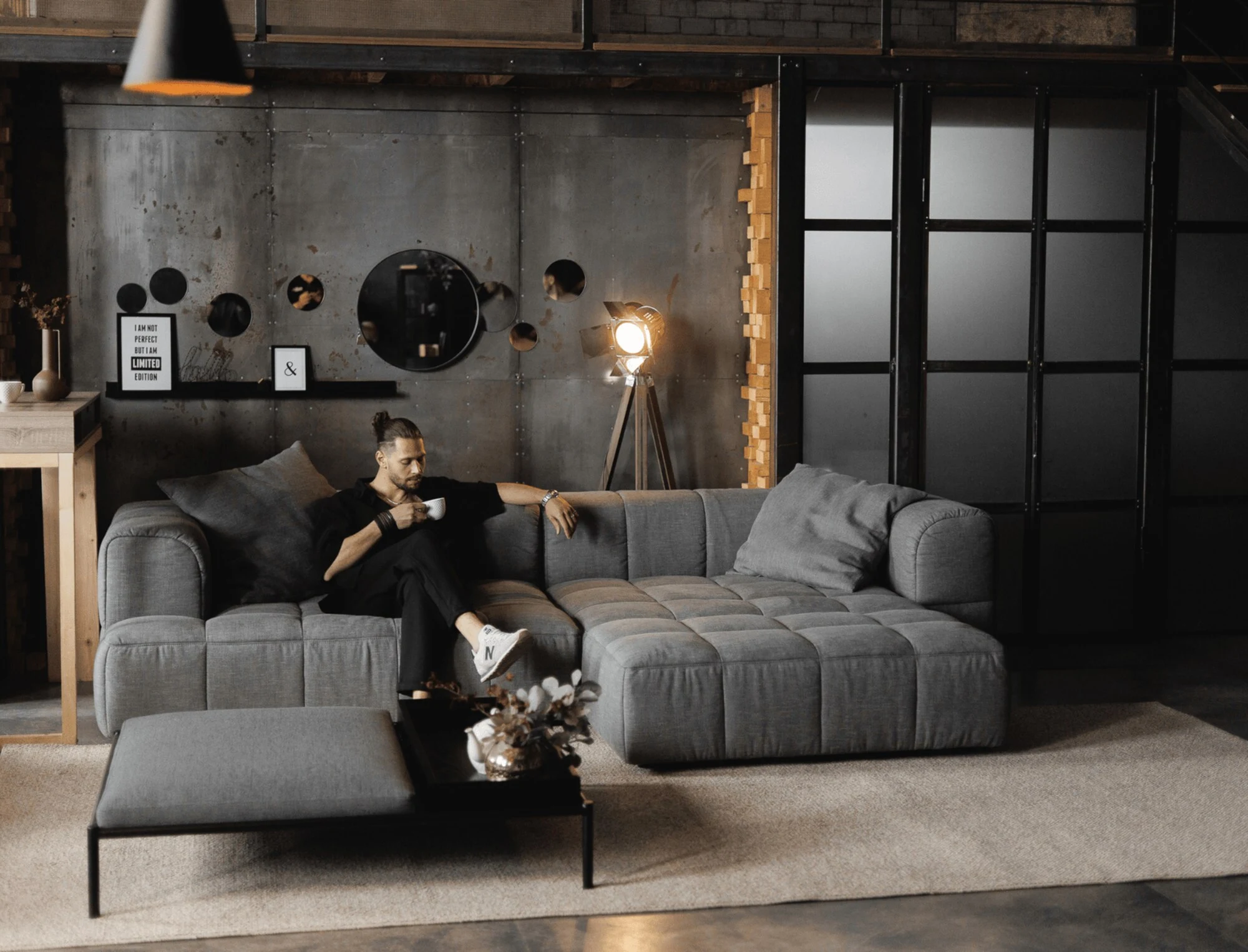Charcoal grey Soft in an industrial loft, a man with coffee, Edison-lamp lighting