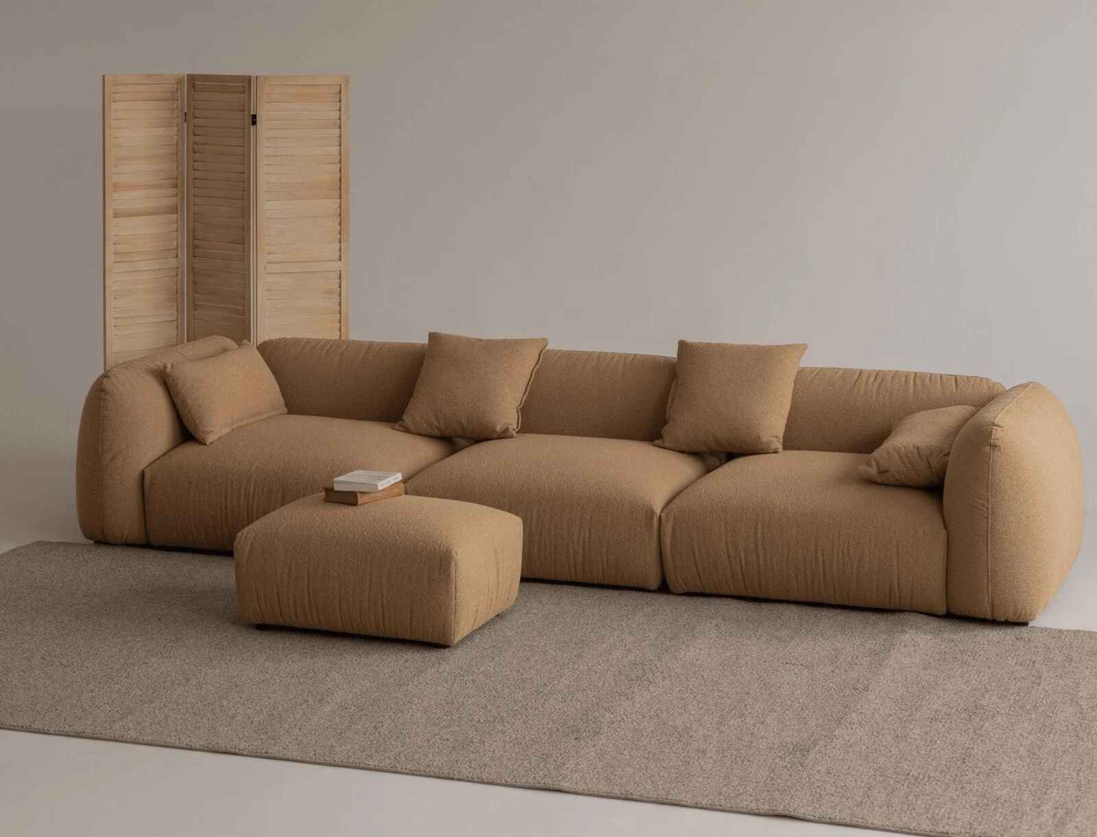 Caramel Tesa with a matching ottoman in front of a folding bamboo screen
