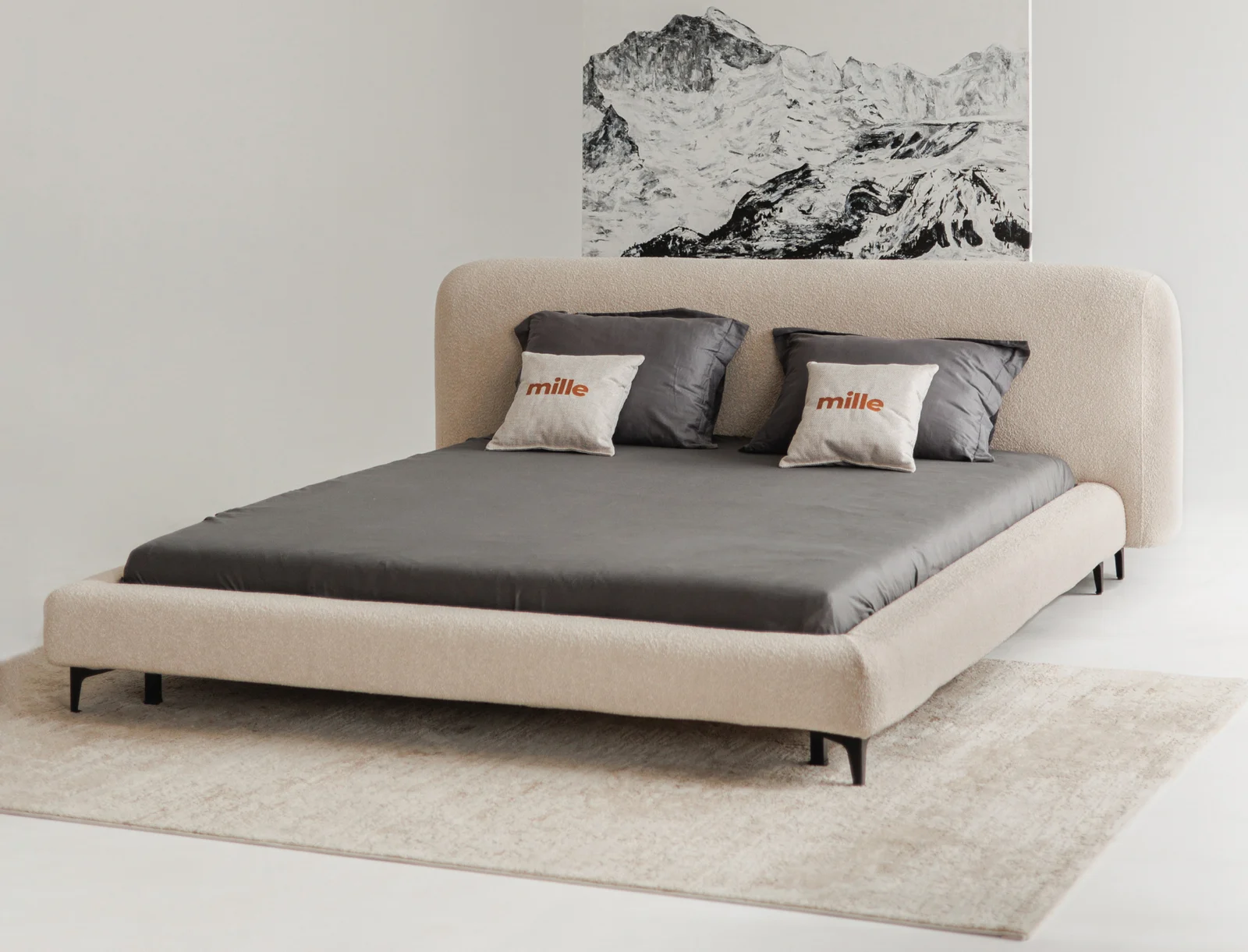 Sand Baloo 2074 boucle Fresco bed in a clean studio with a black-and-white mountain ink drawing behind the headboard, grey duvet and Mille coral pillows on the bed, dark conical legs