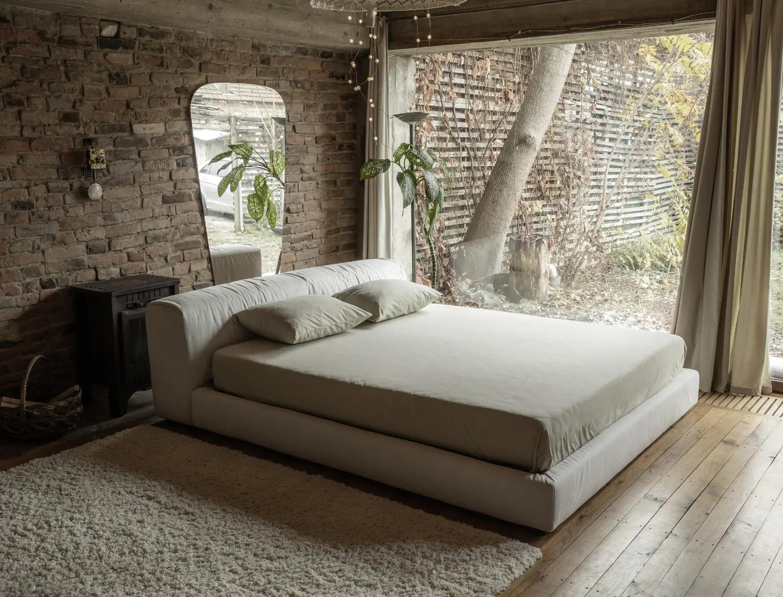 Cream Marmaris in a rustic brick loft with fairy lights overhead and a sunny garden through the window