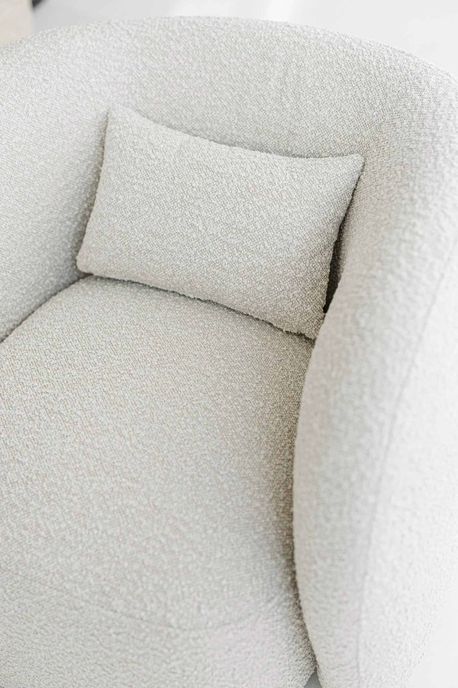 Close detail of the small Mille label sewn into the seam of the cream boucle Nuba armchair